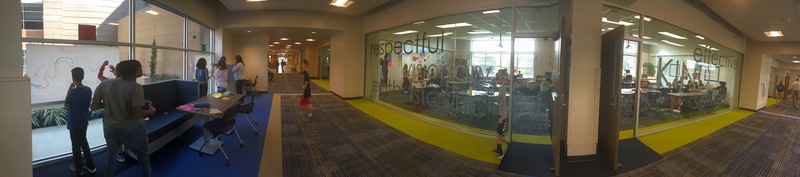 Panaoramic view of hallway including two classrooms and flexible space in between.